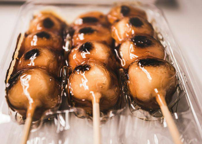 A close-up of mitarashi dango, shiny with syrup.